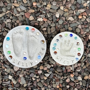 Footprint and handprint stepping stones displayed over river rocks