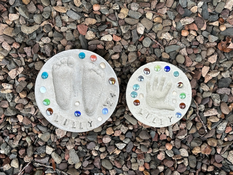 Footprint and handprint stepping stones displayed over river rocks