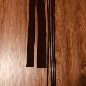 May include: Two black adjustable straps with silver buckles and five black cable ties.