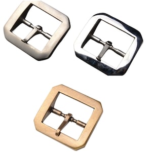 May include: Three metal belt buckles in different finishes: silver, gold, and nickel. Each buckle is rectangular in shape with a smooth, polished surface.