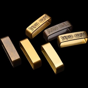 Puede incluir: Un conjunto de seis cierres de hebilla de cinturón de metal dorado con un diseño grabado. Los cierres son de varios tamaños y formas.