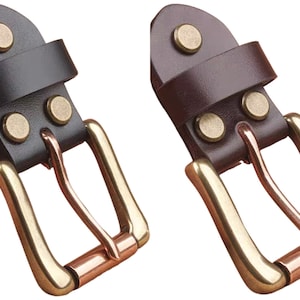 Puede incluir: Dos hebillas de cinturón de cuero con herrajes de latón. Las hebillas son de cuero negro y marrón. Las hebillas tienen tres remaches de latón en la correa.