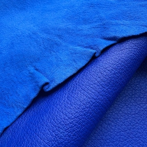 May include: Close-up of two pieces of blue leather. The top piece is a vibrant, textured suede, while the bottom piece is a smooth, pebbled leather. The colors are a deep, rich blue, creating a striking contrast.