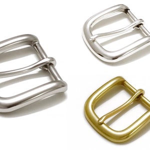 May include: Three metal belt buckles, one silver, one nickel, and one brass. Each buckle has a simple, rounded design.