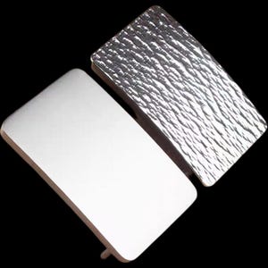 May include: Two silver belt buckles, one with a smooth surface and the other with a textured surface.