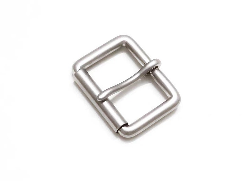 May include: A silver metal buckle for a belt or strap.