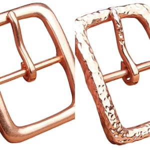 Peut inclure: Deux boucles de ceinture en cuivre, l'une avec une finition lisse et l'autre avec une texture martelée.