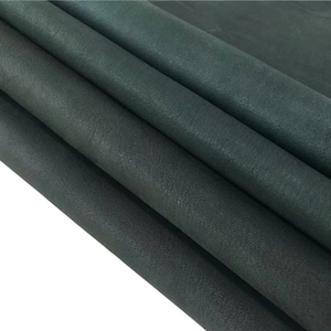 Puede incluir: Primer plano de cuero verde oscuro con una superficie texturizada. El cuero está doblado en tres partes, mostrando el grosor y la veta.