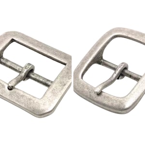 May include: Two silver-toned metal belt buckles with a square shape and a single prong closure.