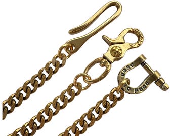May include: A gold-toned metal chain featuring a textured curb link design. The chain includes a hook-style clasp, a swivel lobster claw clasp with a small cross emblem, and a U-shaped shackle connector engraved with the text GOOD VIBES.