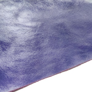Puede incluir: Primer plano de un trozo de cuero morado con un acabado liso y brillante.