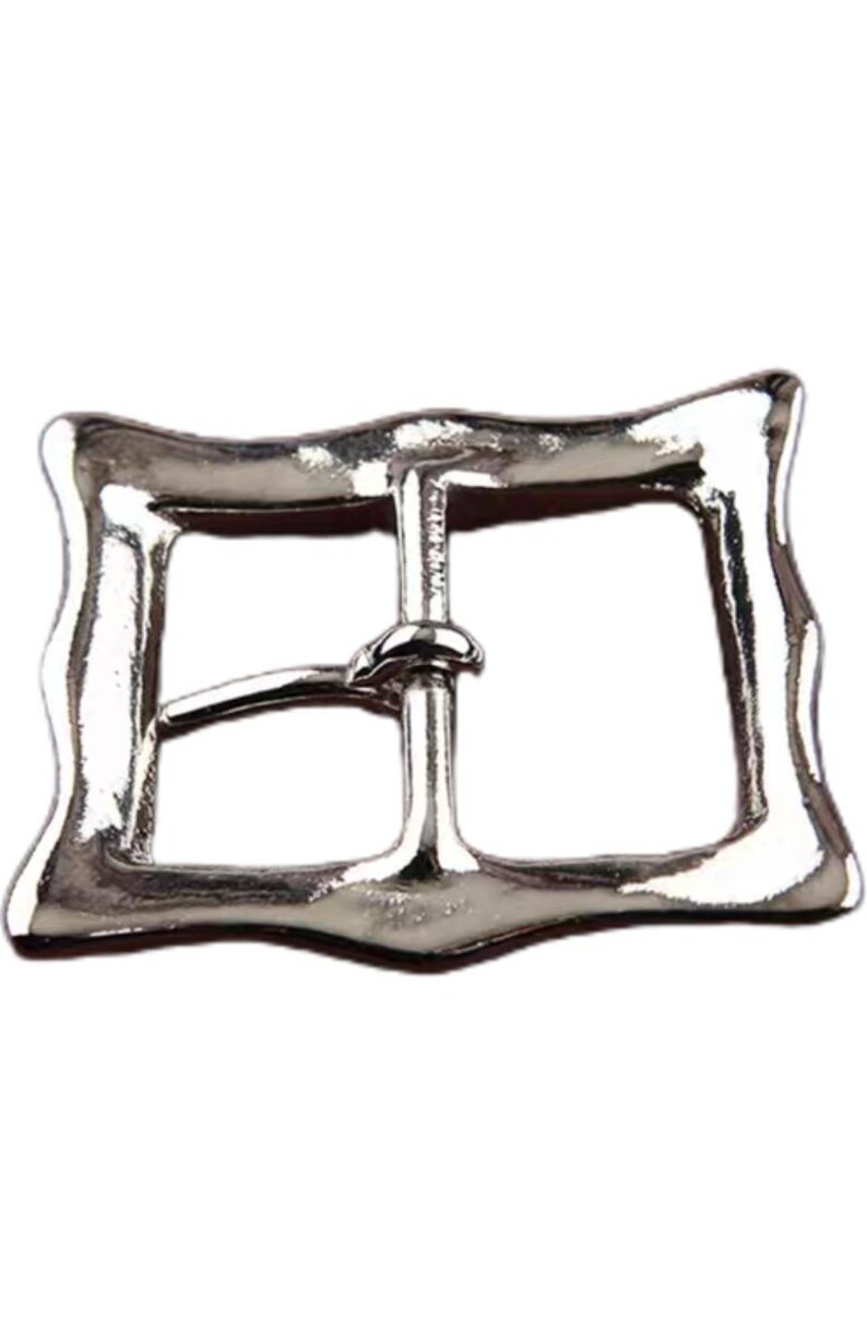 Op de afbeelding: Zilverkleurige metalen gesp met een rechthoekige vorm en een gegolfde rand. De gesp heeft een enkele punt en een gladde afwerking.