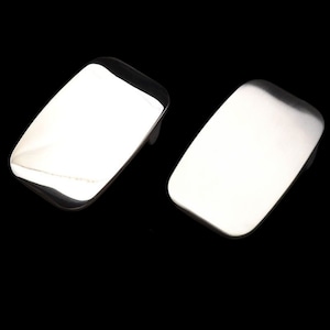 May include: Two silver belt buckles, both rectangular in shape with rounded edges. The buckles are smooth and shiny.