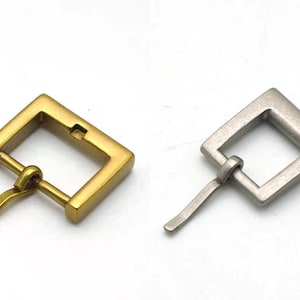 May include: Two metal belt buckles, one gold and one silver, with a square shape and a simple design. The buckles have a spring-loaded mechanism for easy fastening.