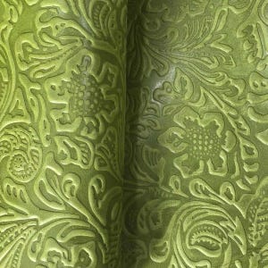 May include: A sheet of lime green material featuring a deeply embossed floral pattern with intricate swirling leaves and textured flower centres. The surface displays a consistent matte finish with raised relief details across the entire area.