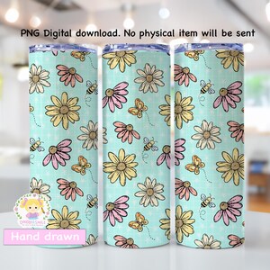 Op de afbeelding: Een bloemenbeker met een lichtblauwe achtergrond, met een patroon van gele, roze en crèmekleurige bloemen, bijen en vlinders. De tekst "PNG Digital download. No physical item will be sent" staat bovenaan. De tekst "Hand drawn" staat onderaan.