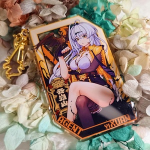 Könnte beinhalten: Ein rechteckiger Acryl-Schlüsselanhänger mit einem Anime-Charakter mit lila Haaren und einer gelben Jacke. Der Schlüsselanhänger hat einen goldfarbenen Verschluss und das Wort "AGENT" ist sichtbar.