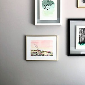 Puede incluir: Tres pinturas de acuarela enmarcadas en una pared gris claro. La pintura superior presenta un fondo de acuarela verde con una bandada de p&aacute;jaros negros volando. La pintura del medio presenta una puesta de sol de acuarela rosa y amarilla sobre un paisaje verde con una bandada de p&aacute;jaros negros volando. La pintura inferior no es visible en la imagen.