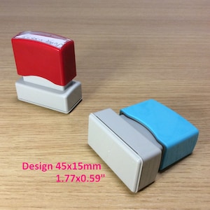 May include: Two rectangular self-inking stamps, one red and one blue, with a white base. The stamps are 1.77 inches by 0.59 inches and are labeled "Design 45x15mm".