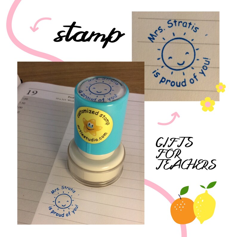 May include: A blue and yellow self-inking stamp with the text "Mrs. Stratis is proud of you!" and a smiling sun graphic. The stamp is on a white background with a notebook and a yellow flower.