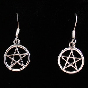 May include: A pair of silver earrings with a pentagram design. The earrings are dangle style with a silver hook.