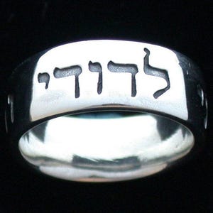 May include: A silver ring with the Hebrew word "Chai" engraved on it. The word "Chai" means "life" in Hebrew.