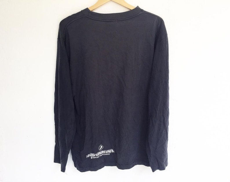 May include: Black long-sleeve shirt with a white graphic print on the bottom. The graphic print says "The Killers" and "Sam's Town".