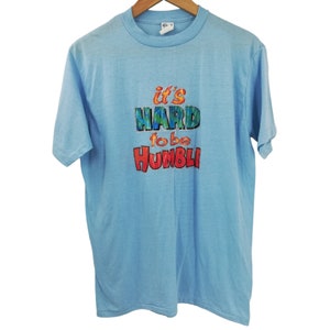 T-shirt vintage blu a punto singolo &quot;Difficile essere umile&quot; taglia XL Glitter Ched anni &#39;70