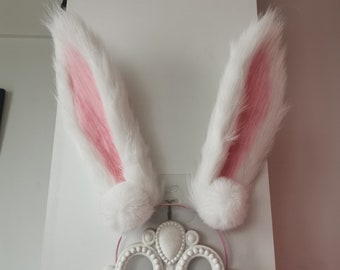 May include: A pair of white bunny ears with pink fur lining the inside. The ears are attached to a headband.