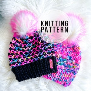 Könnte beinhalten: Zwei bunte Strickmützen mit flauschigen rosa Bommeln. Die Mützen sind aus einem dicken Garn gefertigt und haben einen schwarzen Bund am unteren Rand. Der Text "KNITTING PATTERN" ist auf dem Bild zu sehen.