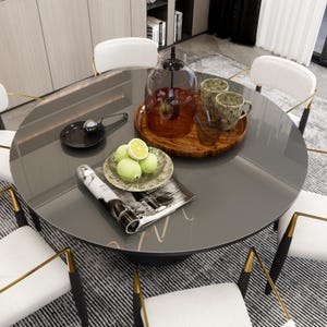 Könnte beinhalten: Ein runder Glastisch mit einer schwarzen Tischplatte und goldenen Akzenten. Der Tisch ist mit einer Zeitschrift, einem Teller mit Zitronen, einem Tablett aus Holz mit zwei Bechern und einer Glasglocke gedeckt.