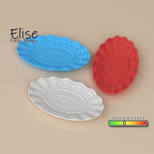 Puede incluir: Tres platos ovalados decorativos en blanco, azul y rojo con un diseño ornamentado. Los platos están hechos de un material liso y brillante y tienen un borde ligeramente elevado. Los platos son perfectos para agregar un toque de elegancia a cualquier mesa.