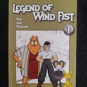Puede incluir: Portada de cómic "Legend of Wind Fist" con tres personajes de dibujos animados y el número "1". El título está en letras grandes y en negrita, con los nombres de los autores debajo. El fondo es de color beige claro.