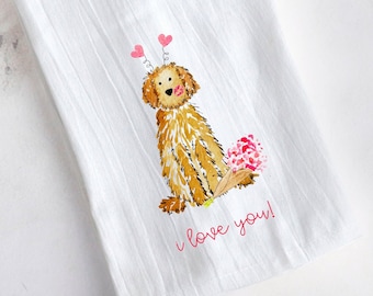 May include: White kitchen towel with a watercolor illustration of a golden doodle dog with pink heart accents and a bouquet of flowers. The text "I love you!" is printed in pink.