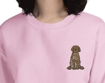 May include: A pink sweatshirt with a brown doodle of a dog sitting on the left chest.