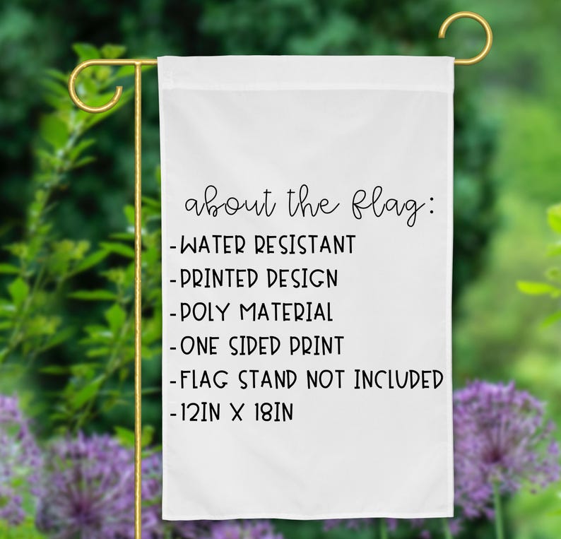 Pode incluir: Uma bandeira de jardim retangular branca com texto preto que diz: about the flag: -WATER RESISTANT -PRINTED DESIGN -POLY MATERIAL -ONE SIDED PRINT -FLAG STAND NOT INCLUDED -30,48 cm X 45,72 cm. A bandeira est&aacute; num suporte de metal dourado.