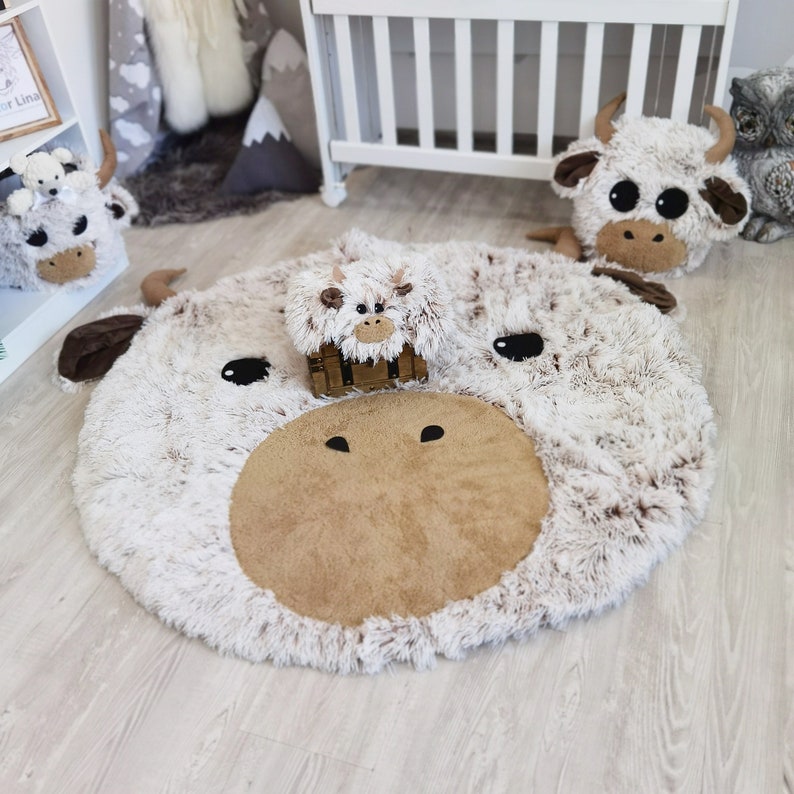 Plush Highland cow rug paired with a coordinating plush pillow in a nursery setting, showcasing the soft, child-friendly design perfect for a cozy and playful children's room.
