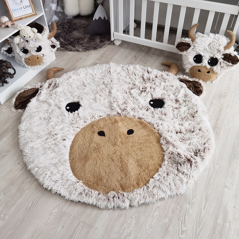 Spacious Highland cow themed nursery with a large, soft rug and matching plush pillow, creating a cozy and inviting space for children. Ideal for baby shower gifts and modern kids' rooms