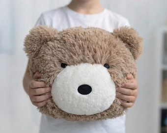 Almohada de peluche color topo cálido con forma de oso: decoración suave para la habitación del bebé.