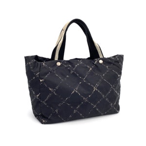 May include: Black quilted tote bag with white straps and a diamond pattern.
