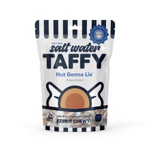 May include: A white bag of salt water taffy with a blue and white logo that says "Tickling Tastebuds Since 1988". The bag has a black and white striped pattern and says "Salt Water Taffy" in bold black letters. The taffy flavor is "Nut Gonna Lie" (Peanut Butter). The bag also says "Keep It Chewy!" and shows a cartoon image of a taffy piece.