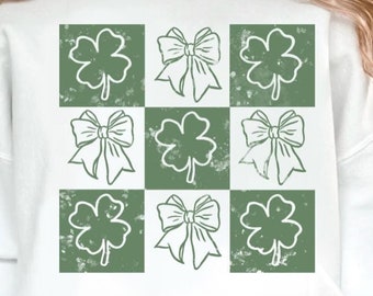 Puede incluir: Sudadera blanca con un patrón de cuadros verde y blanco con tréboles de cuatro hojas y lazos.