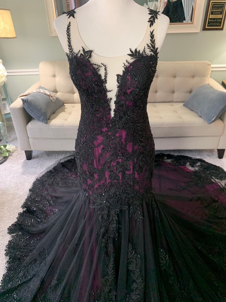 May include: A black and purple mermaid style gown with black lace detailing and a sheer bodice.