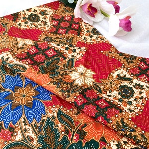 May include: Red, orange, blue, green, and white floral patterned fabric with a repeating design. The fabric has a subtle shimmer.