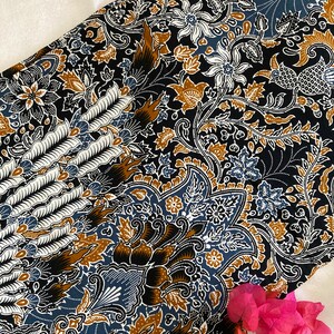May include: A black fabric with a blue, brown, and white floral pattern. The fabric has a paisley design and is ideal for crafting projects.