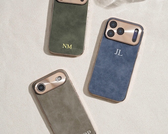 Op de afbeelding: Drie gepersonaliseerde telefoonhoesjes in olijfgroen, blauw en grijs. Elke hoes heeft een goudkleurig camerakader en een bijpassende gouden rand. De hoesjes zijn voorzien van de initialen "NM", "JL" en "BP".