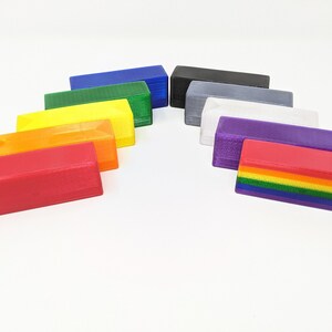 May include: A set of ten rectangular blocks in various colors, including red, orange, yellow, green, blue, purple, gray, white, black, and a rainbow block. The blocks are arranged in a semi-circle shape.