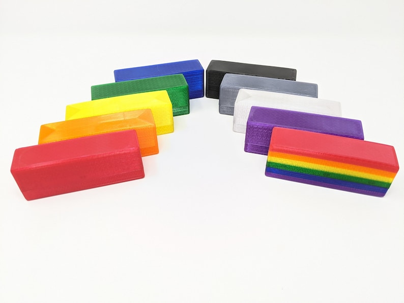May include: A set of ten rectangular blocks in various colors, including red, orange, yellow, green, blue, purple, gray, white, black, and a rainbow block. The blocks are arranged in a semi-circle shape.