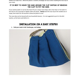 May include: A blue reusable face mask with a white trim. The mask is folded in half, showing the nose clip. The text "IT IS BEST TO WEAVE THE MASK AROUND THE CLIP INSTEAD OF BENDING THE CLIP TO FIT THE MASK." is printed on the page. The text "INSTALLATION (IN 4 EASY STEPS!)" is printed on the page. The text "1. Fold your mask in half. Hamburger, not hotdog." is printed on the page.