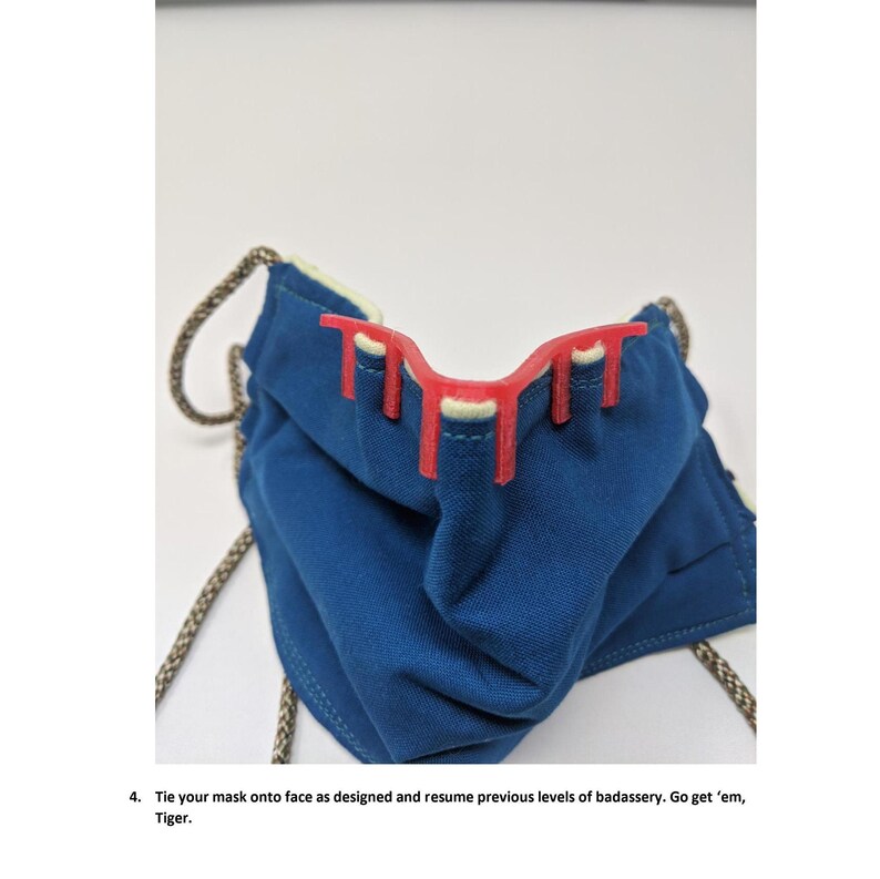 May include: A blue fabric face mask with a red plastic nose wire. The nose wire is designed to help the mask fit snugly over the nose.